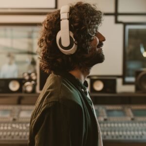 side view of sound producer in headphones enjoying music at studio